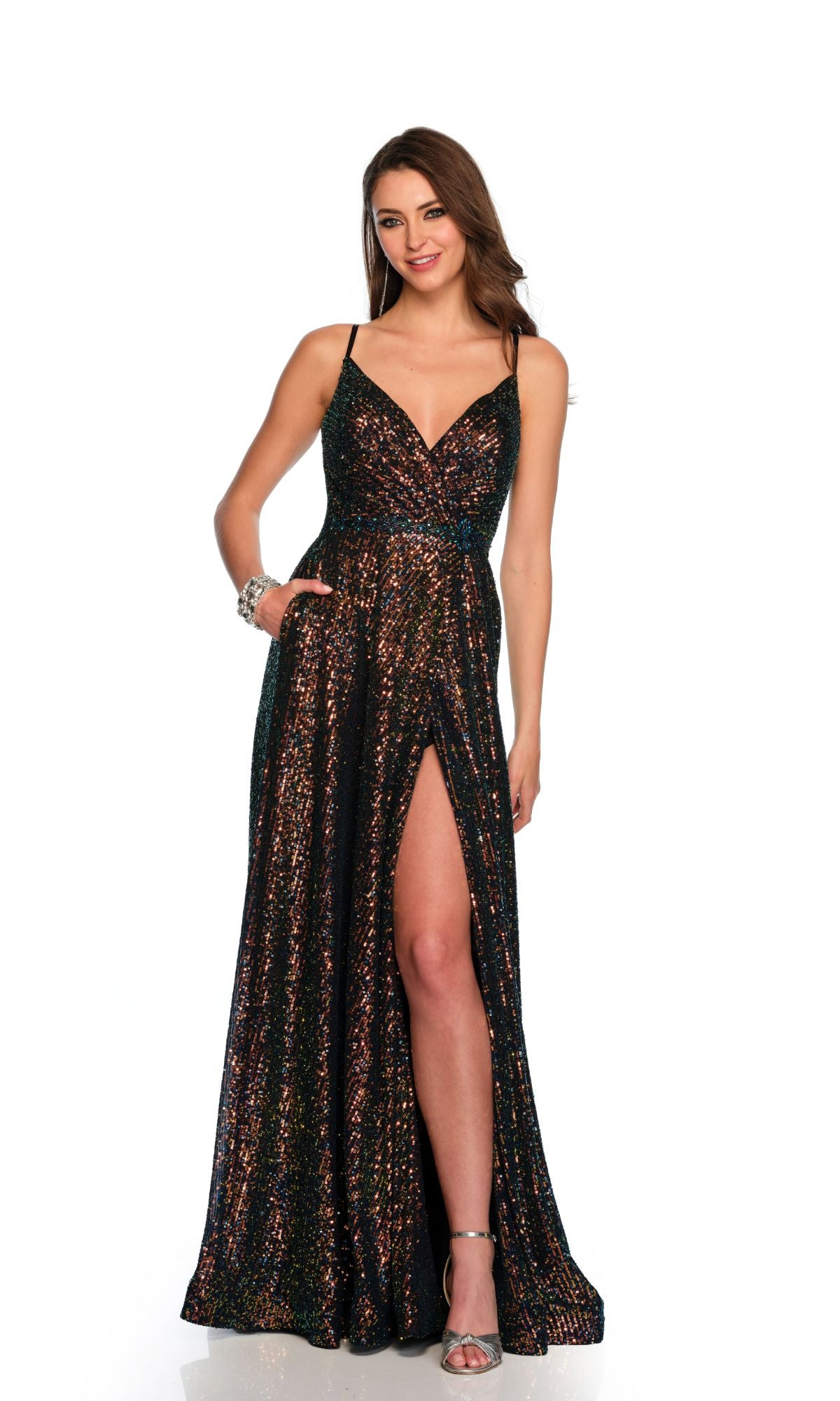 A woman models the Dave & Johnny 11278 long black sequin prom dress with spaghetti straps and a high slit, paired with silver high-heeled sandals, standing against a white background.